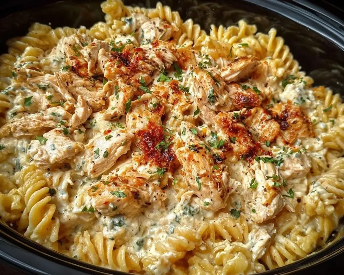 Delicious bowl of Crockpot Garlic Parmesan Chicken Pasta topped with herbs